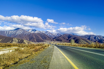 Landscape of asphalt road going off into the mountain passes through the trees, villages and forest...