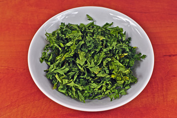 Obraz na płótnie Canvas Dried parsley in a white plastic bowl
