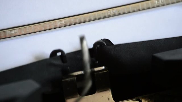 Typing the expression Contact us at: with an old manual typewriter