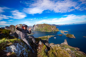 Man on top of a mountain taking a selfie