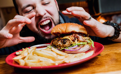 Young man eating a cheeseburger.