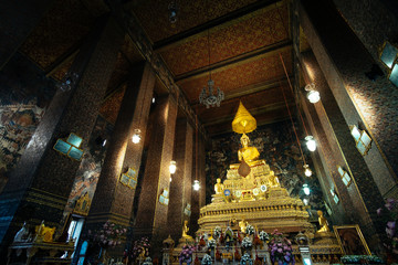 Fototapeta premium Golden Buddha sitting in Wat Pho Buddhist temple, Bangkok, Thailand. Temple of the Reclining Buddha is a famous landmark built during the first king of Thailand