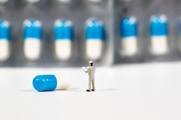 miniature people on the drugs or pils on white,medical concept