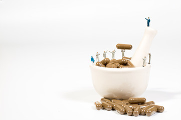 miniature people on the drugs or pils on white,medical concept