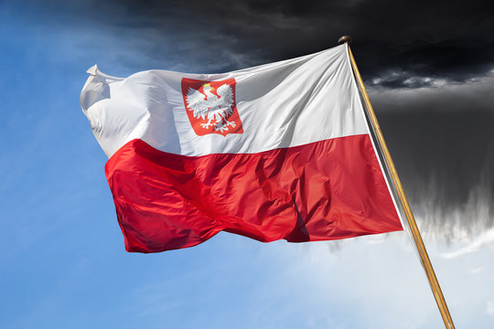 Polish national flag on dramatic sky.