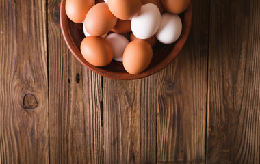 White and brown eggs in a ceramic bowl on a wooden background. Rustic Style. Eggs.  Easter photo concept. Copyspace