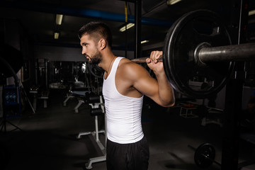 Fototapeta na wymiar Muscular young man is working out in gym
