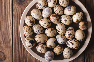 Quail eggs in a brown plate on a wooden table. Rustic Style. Eggs.  Easter photo concept. Copyspace