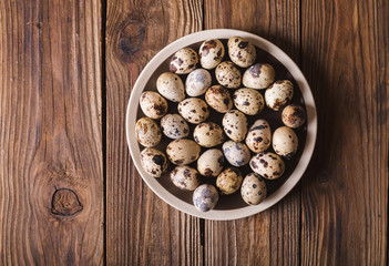 Quail eggs in a brown plate on a wooden table. Rustic Style. Eggs.  Easter photo concept. Copyspace