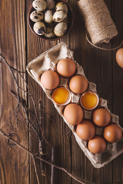 Eggs and broken eggs and quail eggs in the package on a wooden background. Rustic Style. Eggs.  Easter photo concept. Copyspace