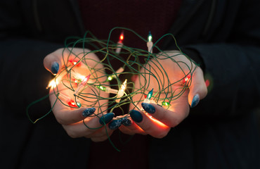 Light garland in the hands of a girl