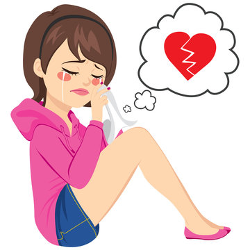 Young sad woman crying sitting on floor with broken heart on speech balloon