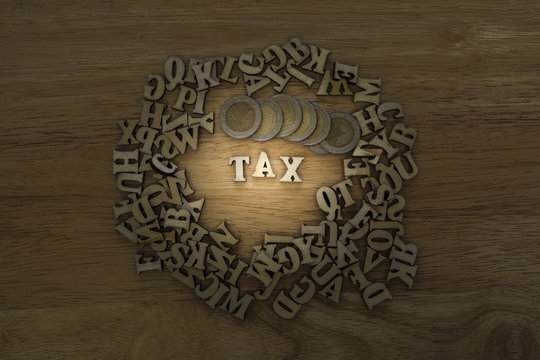 tax word made from plywood with coin stack and man hand,business