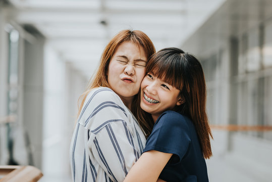 Two Beautiful Happy Asian Girls Friends Laughing And Hug. Friendship Concept.