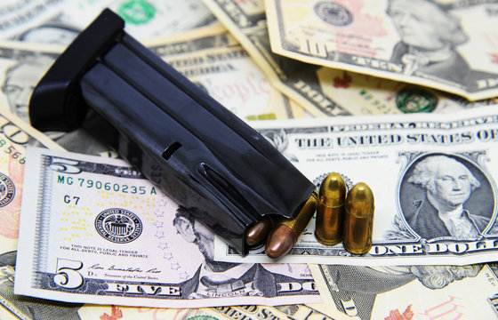 Gun magazine and pistols on dollar banknotes