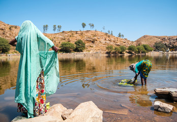 Indian village women washing clothes in the lake. Nygda village, Rajasthan, India
