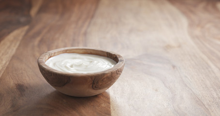 Obraz na płótnie Canvas organic yogurt with spoon from wood bowl, 4k photo