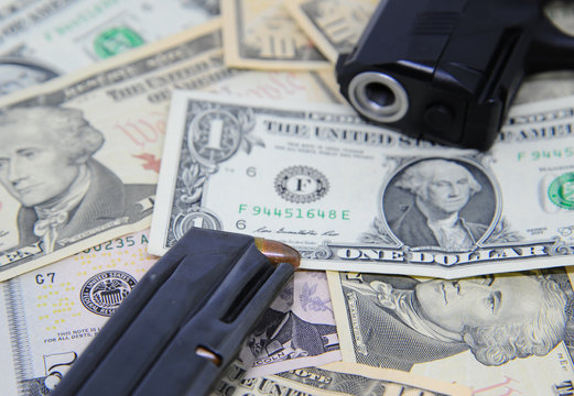 Dollar banknotes with gun and magazine