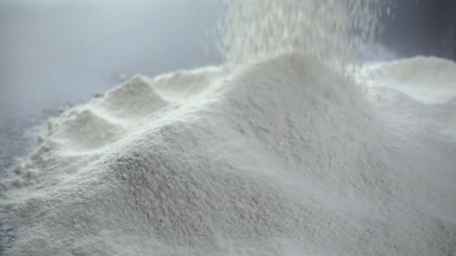 Sifting flour. Slow motion shot of wheat flour heap.