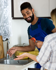 Satisfied girl thanking black professional plumber