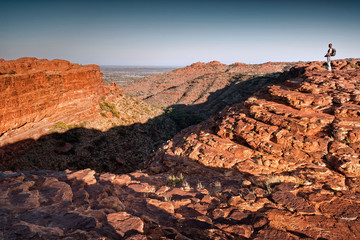 Lone female hiker looks across Kings Canyon in morning light