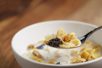 eating corn flakes with fruits and nuts in white bowl, healthy food