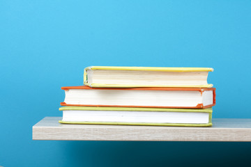 Stack of books on wooden shelf. Education background. Back to school. Copy space for text.