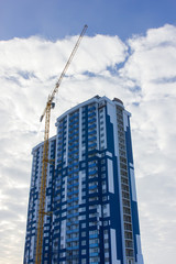 Fototapeta premium Crane and building construction site against blue sky