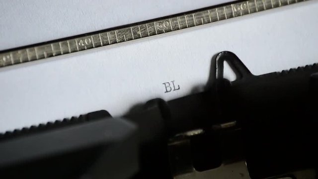 Typing the word BLOGGING with an old manual typewriter