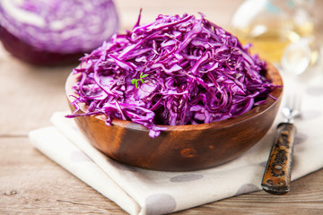 Obraz na płótnie Canvas Red cabbage salad in a bowl on a table. Selective focus. Copy space.