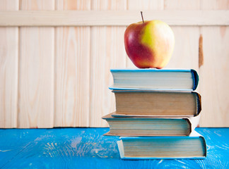 Stack of books and fresh apple