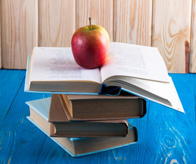 Stack of books and fresh apple