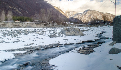 Winter river landscape. Snow covered stream at the mountains of Azerbaijan. Caucasus