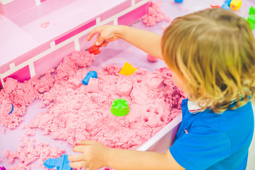 Boy playing with kinetic sand in preschool. The development of fine motor concept. Creativity Game...