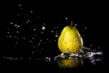 Fototapeta na wymiar Pears fruits and Splashing water on black background