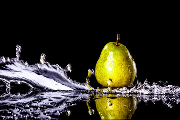 Fototapeta na wymiar Pears fruits and Splashing water on black background