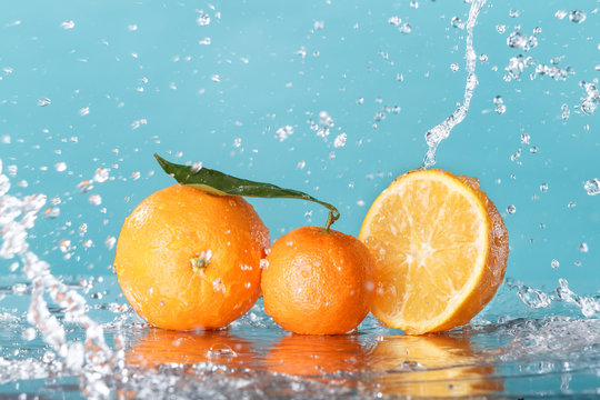 fresh orange with water splash on green background