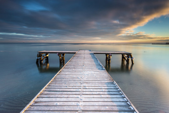 Fototapeta Early morning at frozen small pier at beach in Sopot. Winter landscape in Sopot, Poland.