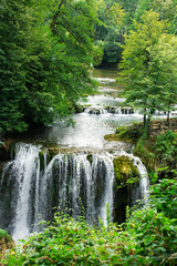 Beautiful forest cascade waterfall with clear, spring river wate