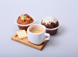 Classic style espresso shot with chip muffin and coffee beans on white background.