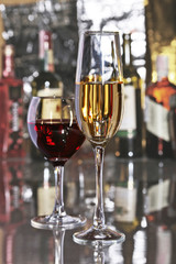 Celebration composition with two glasses white and red wine grapes on mirror table.