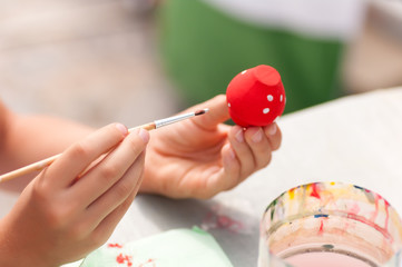 child paints paints toy from clay closeup