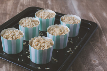Making muffins, adding streusel to the pastry