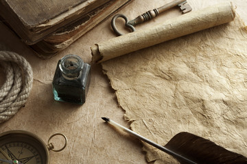 quill pen, inkwell, key, rope, book and compass on antique paper