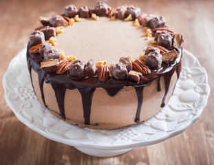 Decorated chocolate and pecan cake close up with chocolate ganache and cream cheese frosting, selective focus