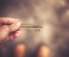 a hand with an antique skeleton key toned with a retro vintage filter