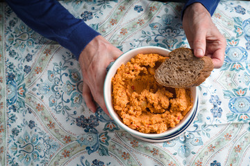 Hummus and bread in a bowl in the hand of a woman close-up