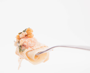 Pasta with cream sauce with bacon, mushrooms, walnuts, spinach on a fork