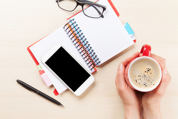 Woman holding coffee cup on business desk
