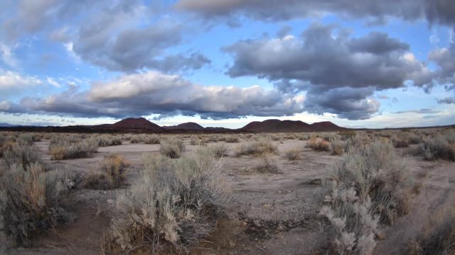 Wide angle time lapse afternoon to dusk with fast drifting clouds over beautiful Mojave landscape in California